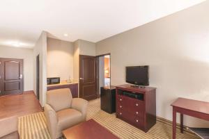 a living room with a tv and a couch and a chair at La Quinta by Wyndham Houston IAH Bush Intl Airport E in Humble