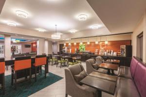 
a dining room with chairs, tables, and a bar at La Quinta by Wyndham Houston Bush Intl Airport E in Humble
