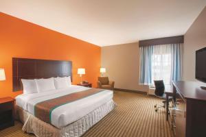 
a hotel room with a bed and a desk at La Quinta by Wyndham Houston Bush Intl Airport E in Humble
