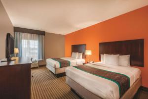 
a hotel room with two beds and two lamps at La Quinta by Wyndham Houston Bush Intl Airport E in Humble
