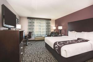 um quarto de hotel com uma cama e uma televisão de ecrã plano em La Quinta by Wyndham Russellville em Russellville