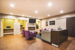 a waiting room with purple chairs and a fireplace at La Quinta by Wyndham Russellville in Russellville