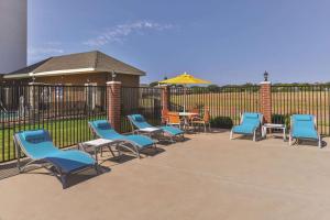 a group of chairs and tables in front of a fence at La Quinta by Wyndham Abilene Mall in Abilene