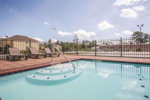 une grande piscine avec une clôture métallique dans l'établissement La Quinta by Wyndham Hattiesburg - I-59, à Hattiesburg