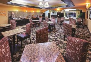 um restaurante com mesas e cadeiras e um bar em La Quinta by Wyndham Searcy em Searcy