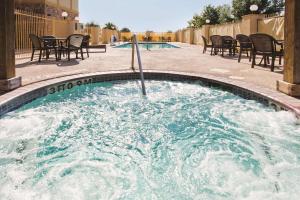 a hot tub with chairs and tables in a pool at La Quinta Inn and Suites by Wyndham - Schertz in Schertz +15 photos