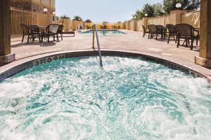 a hot tub with chairs and tables in a pool at La Quinta Inn and Suites by Wyndham - Schertz in Schertz