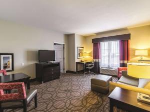 a hotel room with a couch and a television at La Quinta by Wyndham Fargo-Medical Center in Fargo