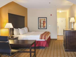 a hotel room with a bed and a desk at La Quinta by Wyndham Mobile Satsuma / Saraland in Satsuma +35 photos