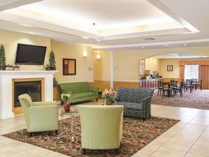 a lobby with couches and chairs and a fireplace at La Quinta by Wyndham Mobile Satsuma / Saraland in Satsuma