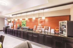 a restaurant with a counter with food on it at La Quinta by Wyndham Houston IAH Bush Intl Airport E in Humble