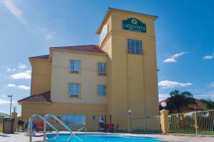 a building with a swimming pool in front of it at La Quinta by Wyndham Alice in Alice