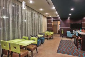 a waiting room with tables and chairs and a tv at La Quinta by Wyndham Cotulla in Cotulla