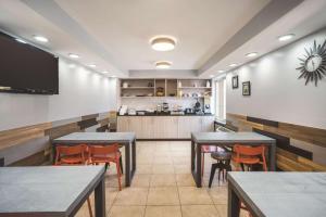 a restaurant with tables and chairs and a kitchen at La Quinta by Wyndham Brooklyn Downtown in Brooklyn