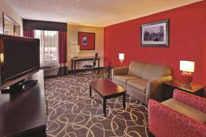 a hotel room with a couch and a television at La Quinta Inn & Suites - New River Gorge National Park in Summersville