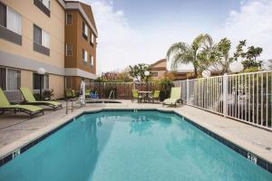 a swimming pool with chairs and a building at La Quinta by Wyndham Dublin - Pleasanton in Dublin