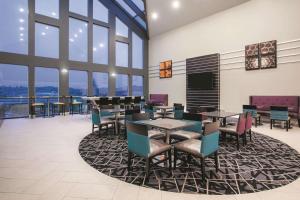 a dining room with tables and chairs and windows at La Quinta by Wyndham Dublin - Pleasanton in Dublin