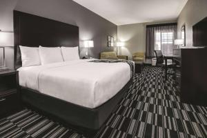 a hotel room with a large bed and a desk at La Quinta by Wyndham Fort Worth West - I-30 in Fort Worth +17 photos