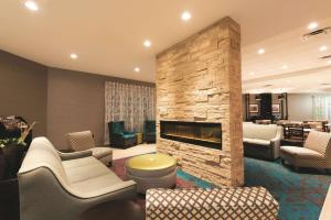 een woonkamer met een stenen open haard en meubilair bij La Quinta by Wyndham Lynchburg at Liberty Univ. in Lynchburg