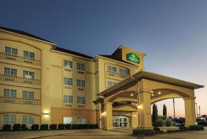 a hotel building with a clock on top of it at La Quinta Inn & Suites by Wyndham South Dallas - Hutchins in Hutchins