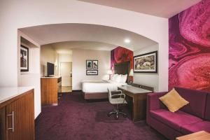 a hotel room with a bed and a couch at La Quinta by Wyndham Chambersburg in Chambersburg