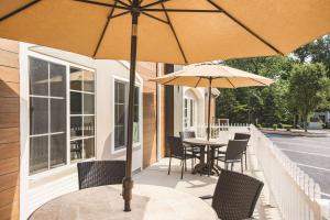 a patio with a table and chairs and umbrellas at La Quinta by Wyndham Chambersburg in Chambersburg
