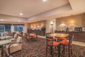 a restaurant with tables and chairs and a bar at La Quinta by Wyndham Verona in Verona