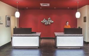 a man standing in front of a red wall at La Quinta by Wyndham Wichita Falls - MSU Area in Wichita Falls +48 photos