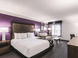 a hotel room with a large bed and a couch at La Quinta by Wyndham Cincinnati Sharonville in Sharonville