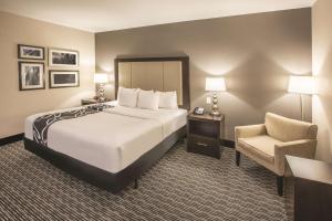 a hotel room with a bed and a chair at La Quinta by Wyndham Hattiesburg - I-59 in Hattiesburg +28 photos