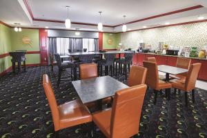 a restaurant with tables and chairs and a bar at La Quinta Inn & Suites by Wyndham South Dallas - Hutchins in Hutchins