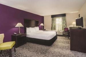 a hotel room with a bed and a television at La Quinta Inn & Suites by Wyndham Louisville East in Louisville