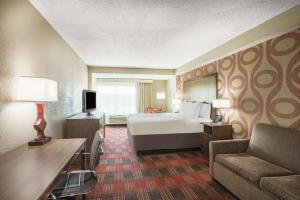 a hotel room with a bed and a desk and a couch at La Quinta Inn & Suites by Wyndham DC Metro Capital Beltway in Capitol Heights +80 photos