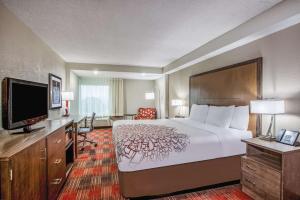 a hotel room with a bed and a flat screen tv at La Quinta Inn & Suites by Wyndham DC Metro Capital Beltway in Capitol Heights