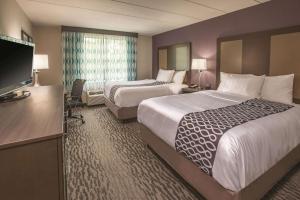 a hotel room with two beds and a flat screen tv at La Quinta by Wyndham Sturbridge in Sturbridge