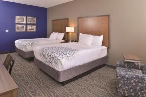 
a hotel room with a bed, chair, and nightstand at La Quinta by Wyndham Page at Lake Powell in Page

