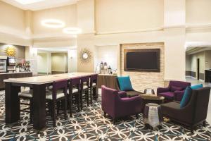 eine Lobby mit einer Bar, Stühlen und einem TV in der Unterkunft La Quinta by Wyndham Newark - Elkton in Elkton