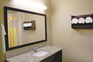 a bathroom with a sink and a mirror and towels at La Quinta by Wyndham Pearsall in Pearsall +26 photos