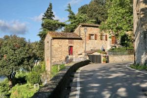 a stone house with a red door on a road at Residenza Antico Chianti in Panzano