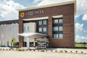 a hotel building with a sunitta sign on it at La Quinta by Wyndham Dallas Plano - The Colony in The Colony