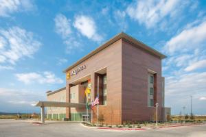 un edificio con una bandera americana delante de él en La Quinta by Wyndham San Marcos Outlet Mall en San Marcos