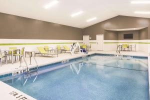 a swimming pool with chairs and tables and chairs at La Quinta by Wyndham Milledgeville in Milledgeville