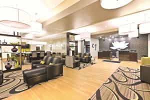 a lobby with leather chairs and a hair salon at La Quinta by Wyndham Billings in Billings