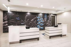 a store with two white counters and a painting on the wall at La Quinta by Wyndham Odessa North - Sienna Tower in Odessa