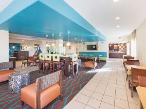 a hotel lobby with a dining area and tables and chairs at La Quinta by Wyndham Mathis in Mathis