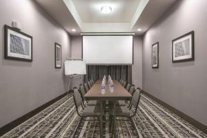 a conference room with a table and chairs and a screen at La Quinta by Wyndham Fort Worth West - I-30 in Fort Worth
