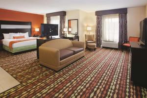 a hotel room with a bed and a couch and a television at La Quinta by Wyndham Florence in Florence