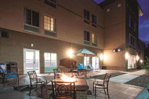 a patio with chairs and tables and an umbrella in front of a building at La Quinta by Wyndham Duluth in Duluth