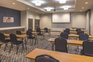 a classroom with tables and chairs and a whiteboard at La Quinta Inn & Suites by Wyndham Atlanta South - McDonough in McDonough