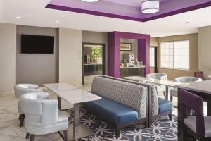 a restaurant with tables and chairs and a flat screen tv at La Quinta by Wyndham Springfield IL in Springfield